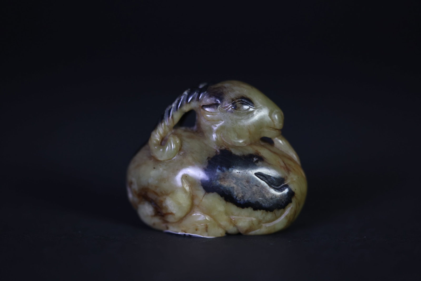Small sugar-brown jade carved sheep with black staining, hand-held ornament: Naturally aged with patina, featuring black and red mineralization, natural stone veining, overall in excellent condition. H 4.2cm W 5cm