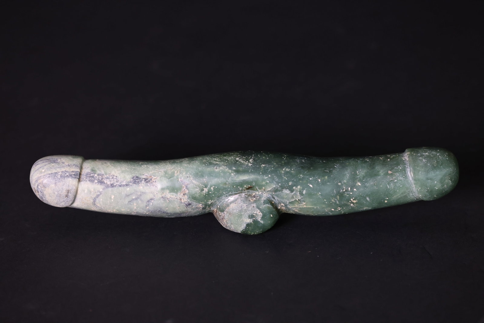 Carved Green Jade Phallic-Form Pendant/Amulet: Natural aging, signs of use, patina, natural stone veining, and calcification. H 5cm W 28cm