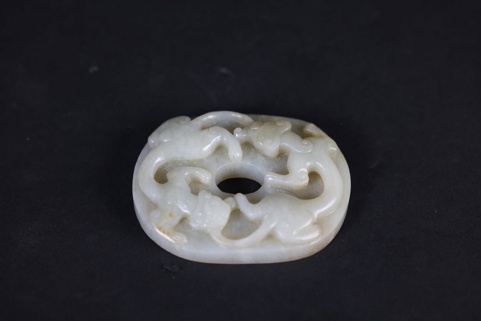 Ming Dynasty Pale Celadon-White Jade Bi with Paired Dragon Reliefs: Naturally aged with patina, otherwise in excellent overall condition. H 1.4cm. W 6.5cm
