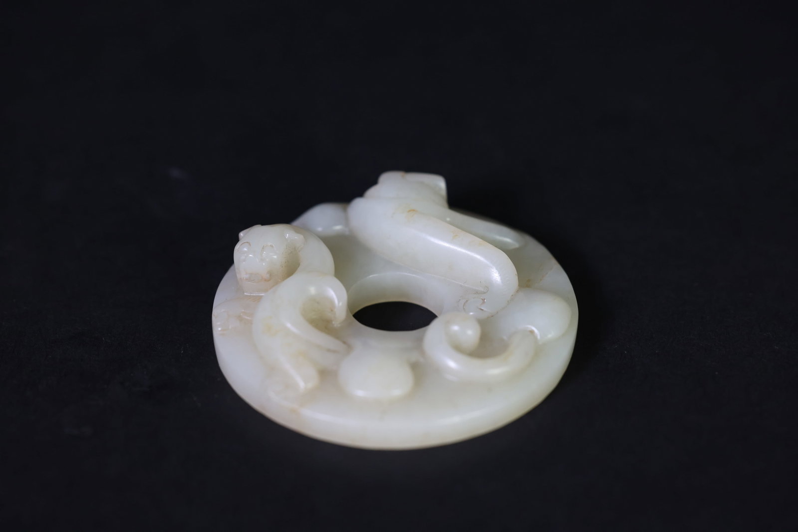 Carved White Jade Bi Disk with Twin Dragons in Relief: Naturally aged patina, otherwise in excellent condition. H 1.7cm. W 6.3cm