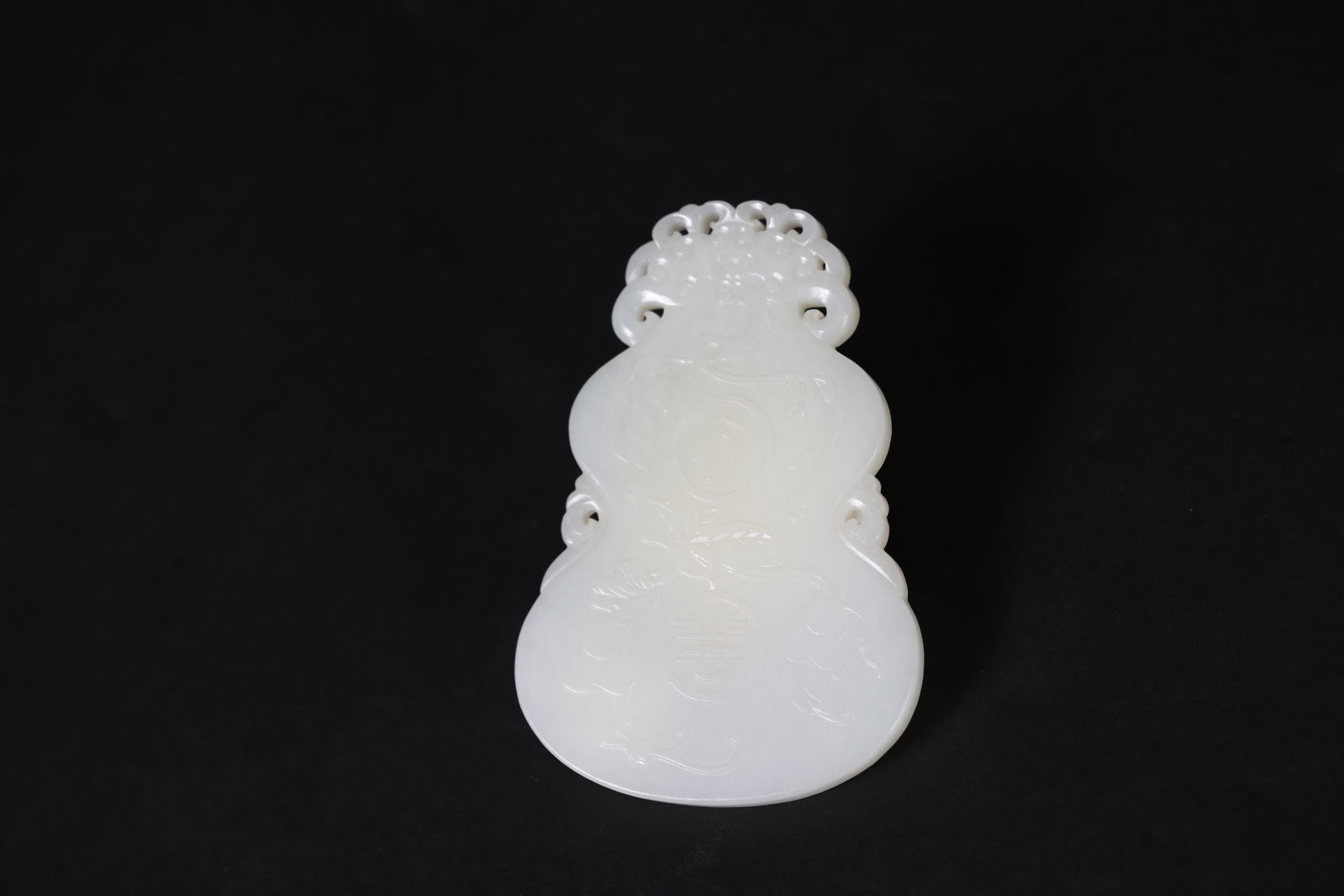 Hetian (Hotan) White Jade Gourd-Shaped Plaque with Gourd Motifs, Inscribed "Tianxi Daji": Naturally aged with patina, otherwise in excellent overall condition. H 10.5cm W 7cm