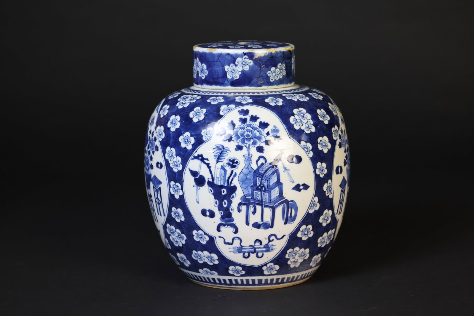 Late Qing blue-and-white open-roundel bogu-pattern ice-crackle plum lidded jar, Kangxi mark: Naturally aged patina; multiple restorations to the rim and corners; drilled holes to the center and base; otherwise in good overall condition. H 28cm W 23cm