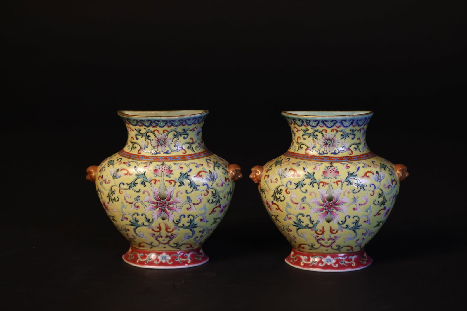 Pair of Mid-Qing Famille Rose Gilt Beast-Head Ear Vases with Lotus Scrolls, Qianlong Mark: Naturally aged with patina and coloration; three of the four beast heads have minor pinhead-sized glaze flakes, otherwise in overall excellent condition. H 13.8cm. W 14cm