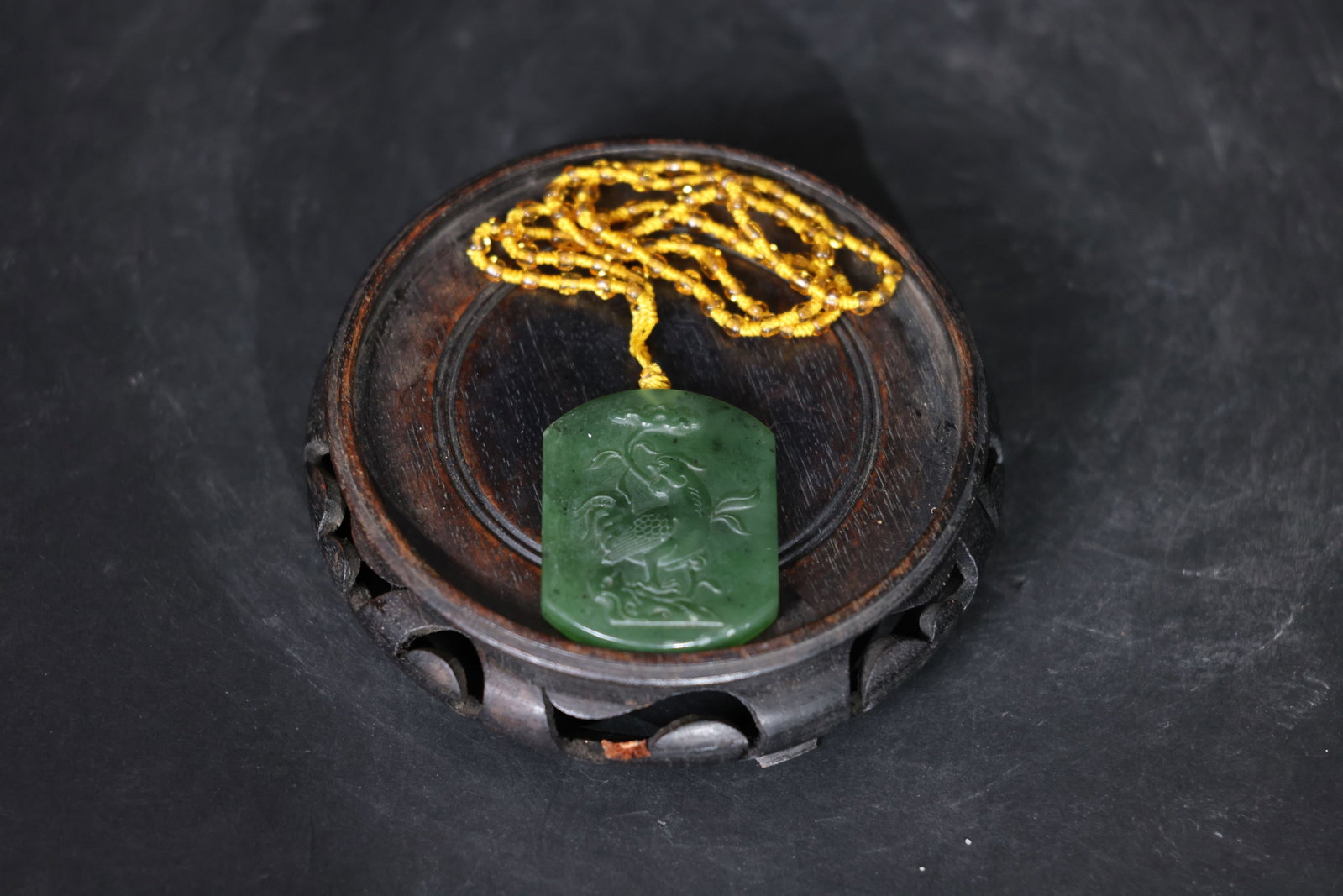 Hetian green nephrite plaque, carved "Promotion to Higher Office" (????): The jade is intact with no cracks, showing minor surface wear consistent with use. Natural black inclusions are present in the nephrite. The suspension cord is in good condition. H 5cm W 4cm