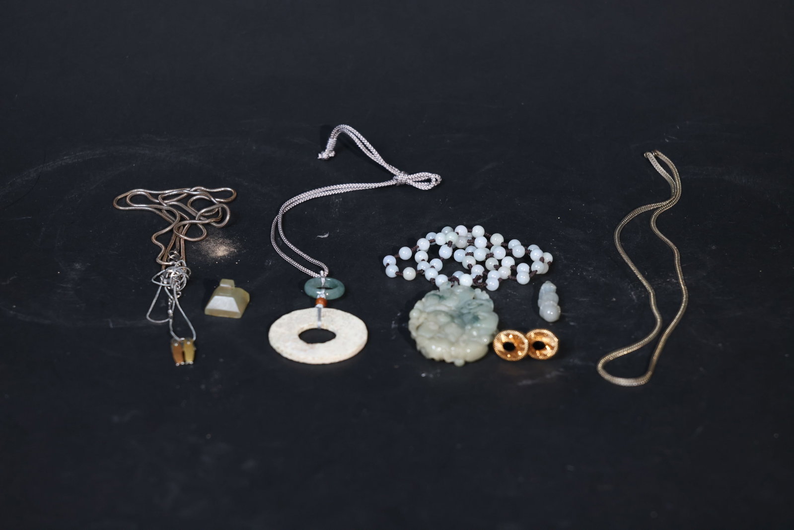 Lot of Antique Jade, Jadeite and Western Jewelry: Partial old patina on the jade seal blank; significant calcification on the ancient jade bi with minor edge wear; natural stone lines present in the jadeite; oxidation and wear on the metal chain;