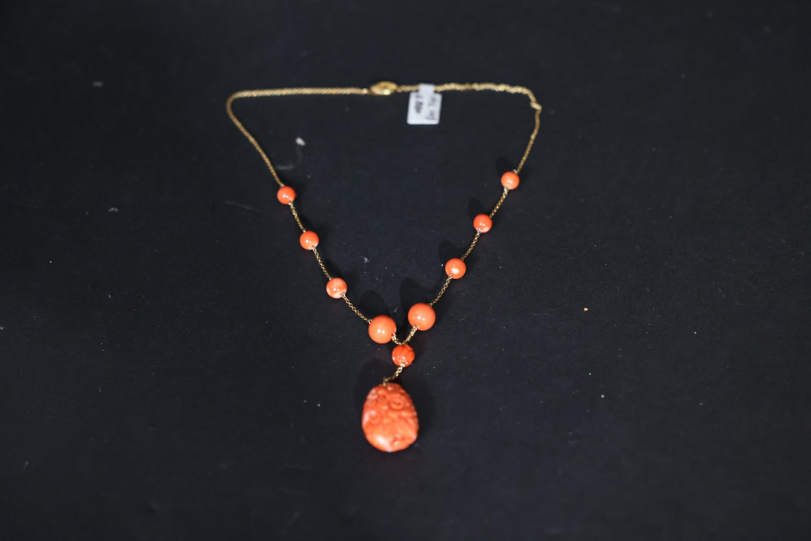 Antique Carved Coral Floral Pendant on Gold Chain: Jadeite is intact with no chips or cracks; the setting is secure. The metal shows minor localized wear to the gilding. Opal is free from significant abrasions. Pin mechanism is in good working order.