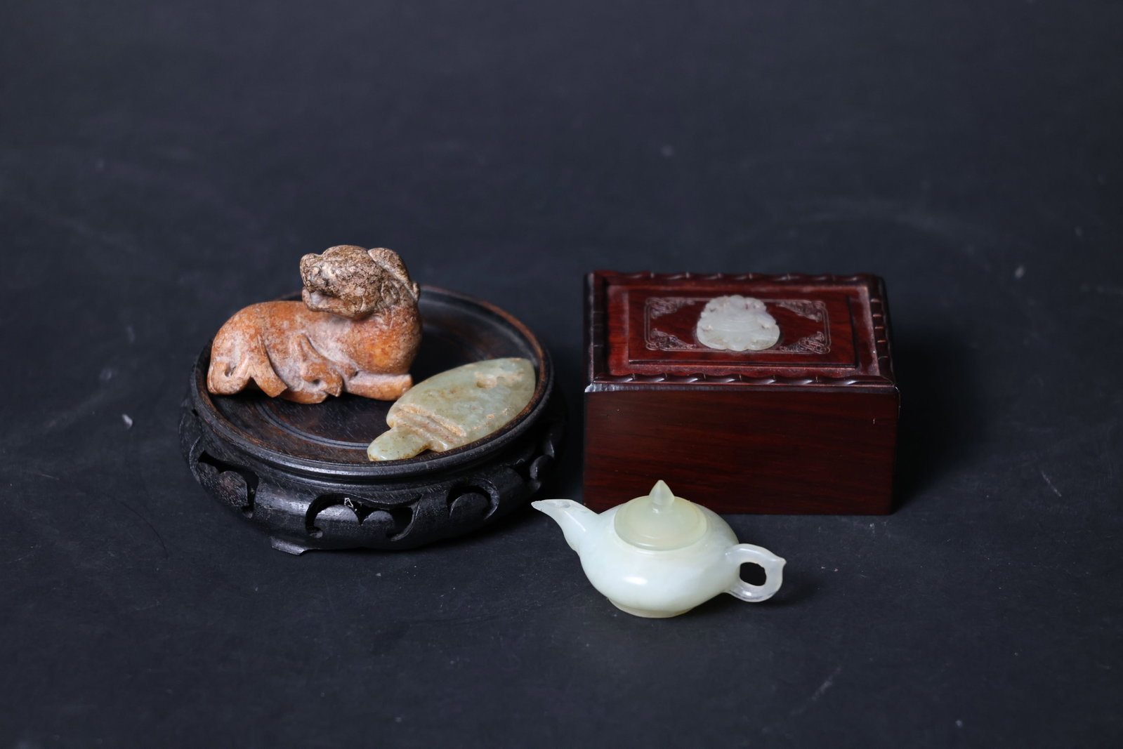 Lot of Assorted Antique Jade Pieces: The mythical beast is intact; the jade dagger-axe pendant has minor nicks to the edges; the serpentine jade miniature vessel is in good condition with no cracks; the wooden box is complete and the jad