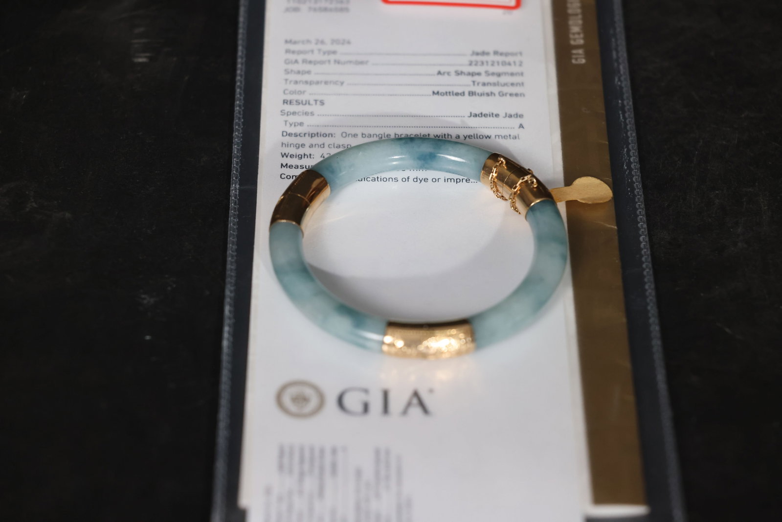 14K Gold Jadeite Bangle, Icy Translucent with Blue Floral Inclusions, GIA Certified: No new cracks in the jade; old splicing craftsmanship visible. Gold clasp shows normal age-related wear. Engraved patterns remain clear. Clasp mechanism functions properly. Weight 42.75g;
