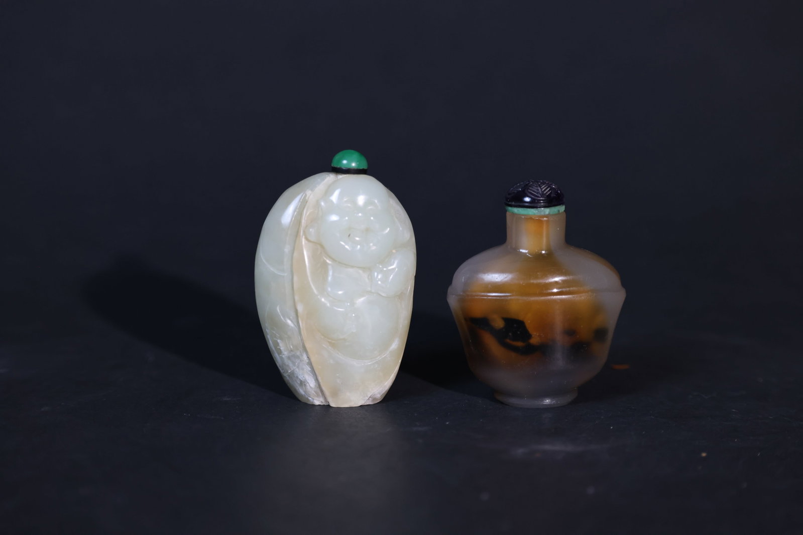 Group of Snuff Bottles: Hetian celadon jade Maitreya snuff bottle: old chips to the base, natural jade veining visible on the body, lid intact, no recent damage overall. Agate snuff bottle with natural inclusions: minor