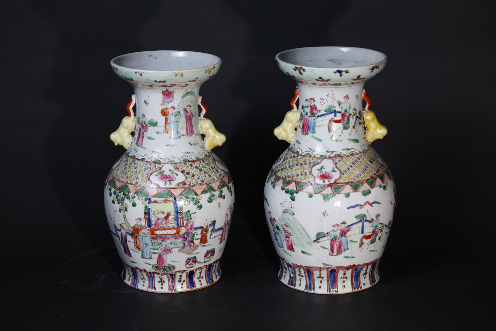Pair of Late Qing Famille Rose Pan-Mouthed Vases with Lion-Head Handles and Figural Decoration: A pair, each with all four lion ears damaged and restored; areas of enamel loss and surface wear; body with old firing lines and signs of age and use; minor glaze fritting to the rim; drilled hole to 