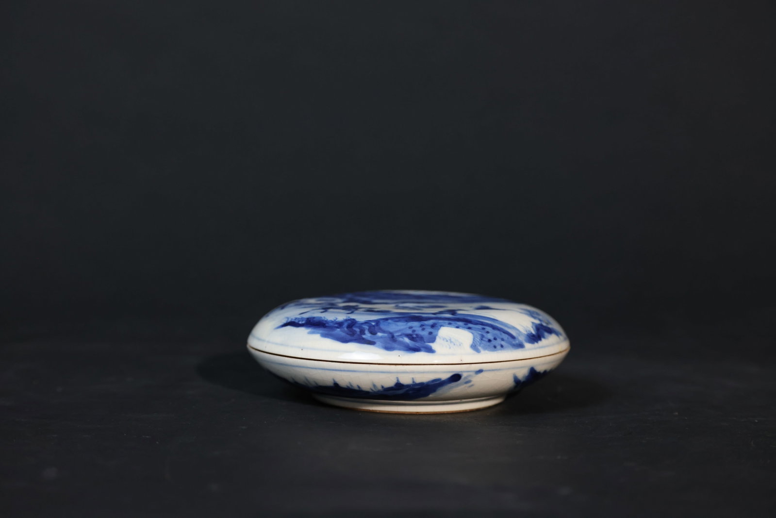 Ge-style Blue-and-White Porcelain Seal Paste Box with Mounted Warrior Figures: Overall intact. The cover has glaze crackle and a short hairline. The rim shows old wear consistent with age and use. No major chips or cracks. Exhibits signs of age and long-term use. H 4cm W 14cm