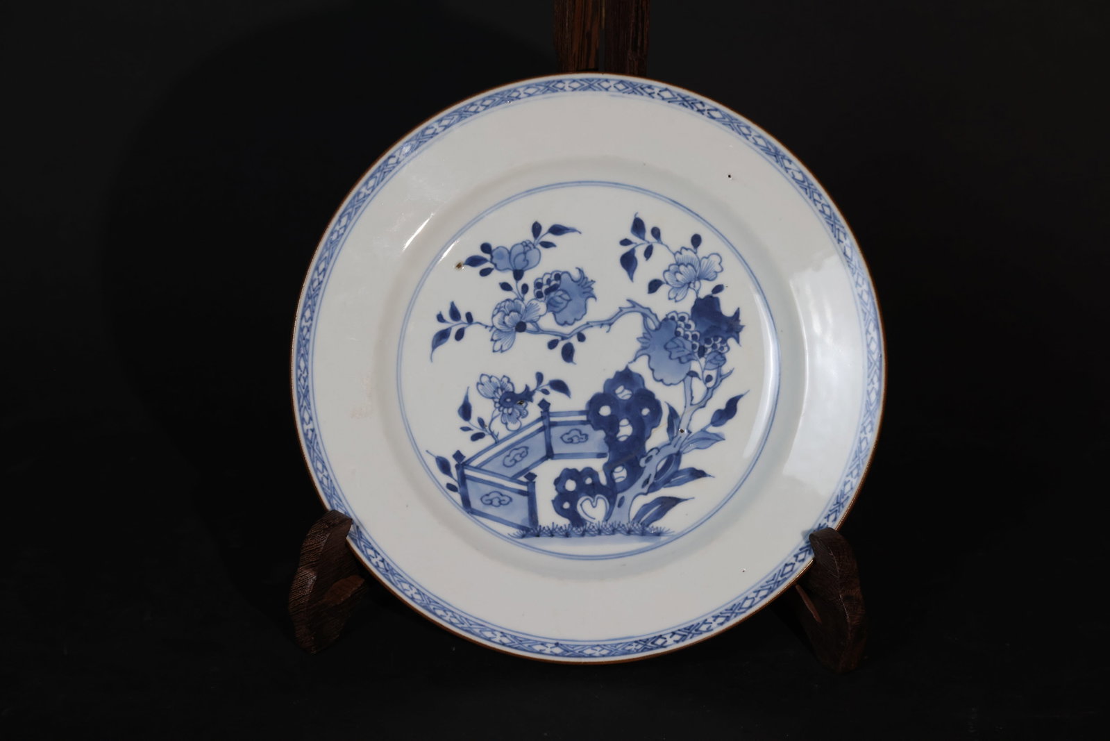 Kangxi Blue-and-White Courtyard Pomegranate and Floral Folded?Rim Dish: There is a firing line at the base extending to the interior, the rim is intact with no chips or cracks, and the glaze shows normal wear consistent with age. H 2.3cm W 12.5cm