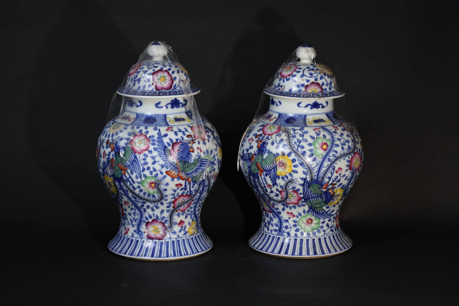 Pair of Guangxu (Qing) Blue-and-White and Enamel 'Phoenix and Peony' General Jars: A pair, lids intact; bodies in good condition. Both bases show firing lines radiating from the center. Minor wear to the rims and finials consistent with age and use, with no chips or losses. H 42cm W