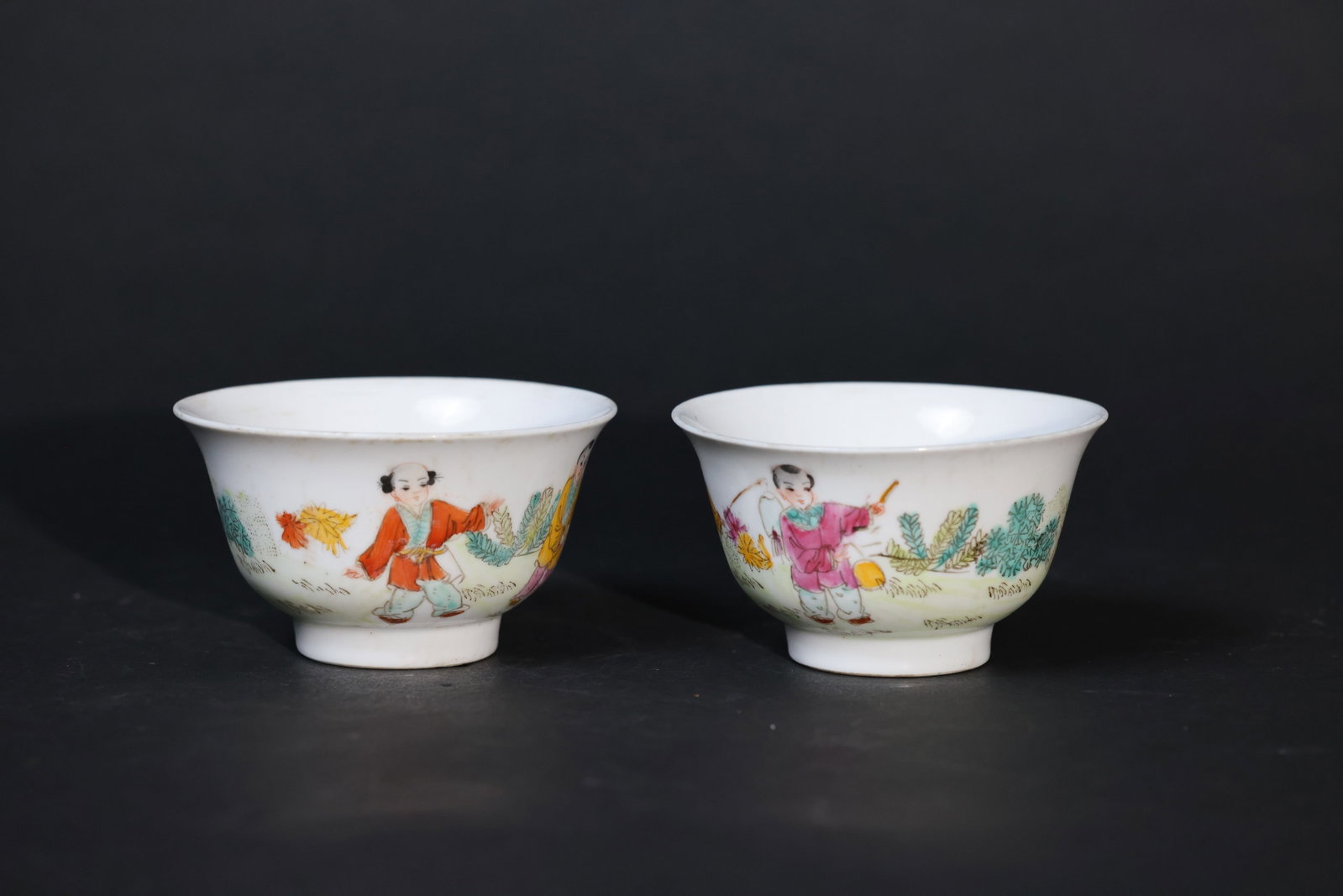 Pair of Famille Rose "Children at Play" Cups: Overall in good condition with minor wear to the rim consistent with age and use; enamels well preserved; no cracks or chips; preserved as a pair. H 6cm W 10.5cm