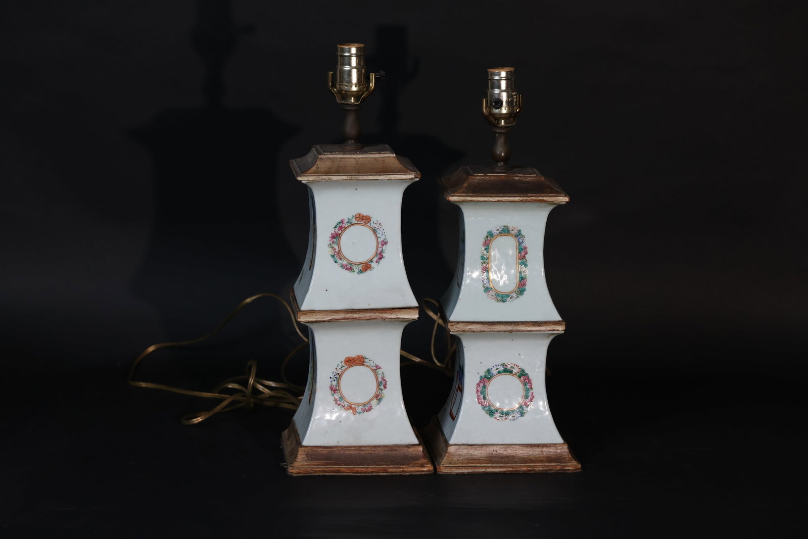 Pair of Famille Rose Porcelain Table Lamps with Bogu and Auspicious Beast Motifs: Porcelain body intact, no major cracks or chips; minor old stains and some wear to the enamels in places. Wooden mounts at top and bottom with wear and losses to the lacquer. Metal lamp fittings aged;
