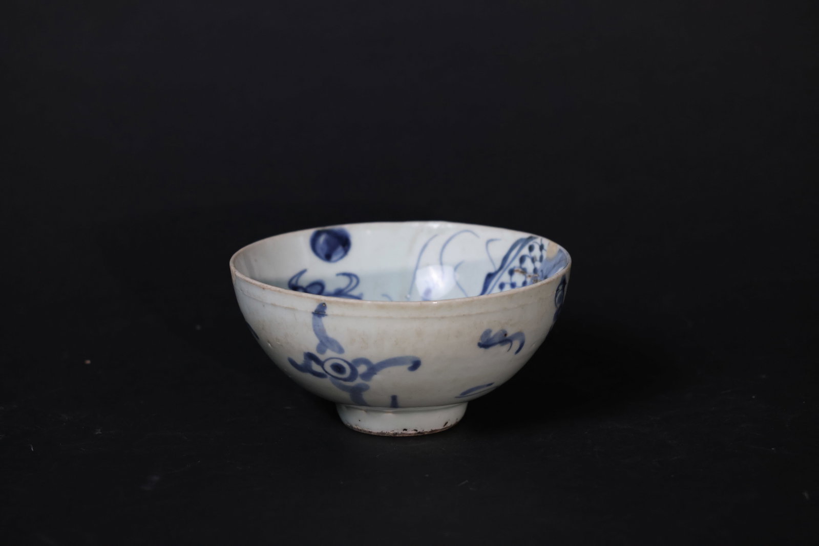 Blue-and-White "Crossing-the-Wall" Dragon Bowl, Mid–Late Qing Dynasty: One small glaze flake to the rim, minor wear to the bowl body consistent with use, and old nicks and wear to the footring; no cracks, overall in good displayable condition. H 10.2cm W 25.5cm