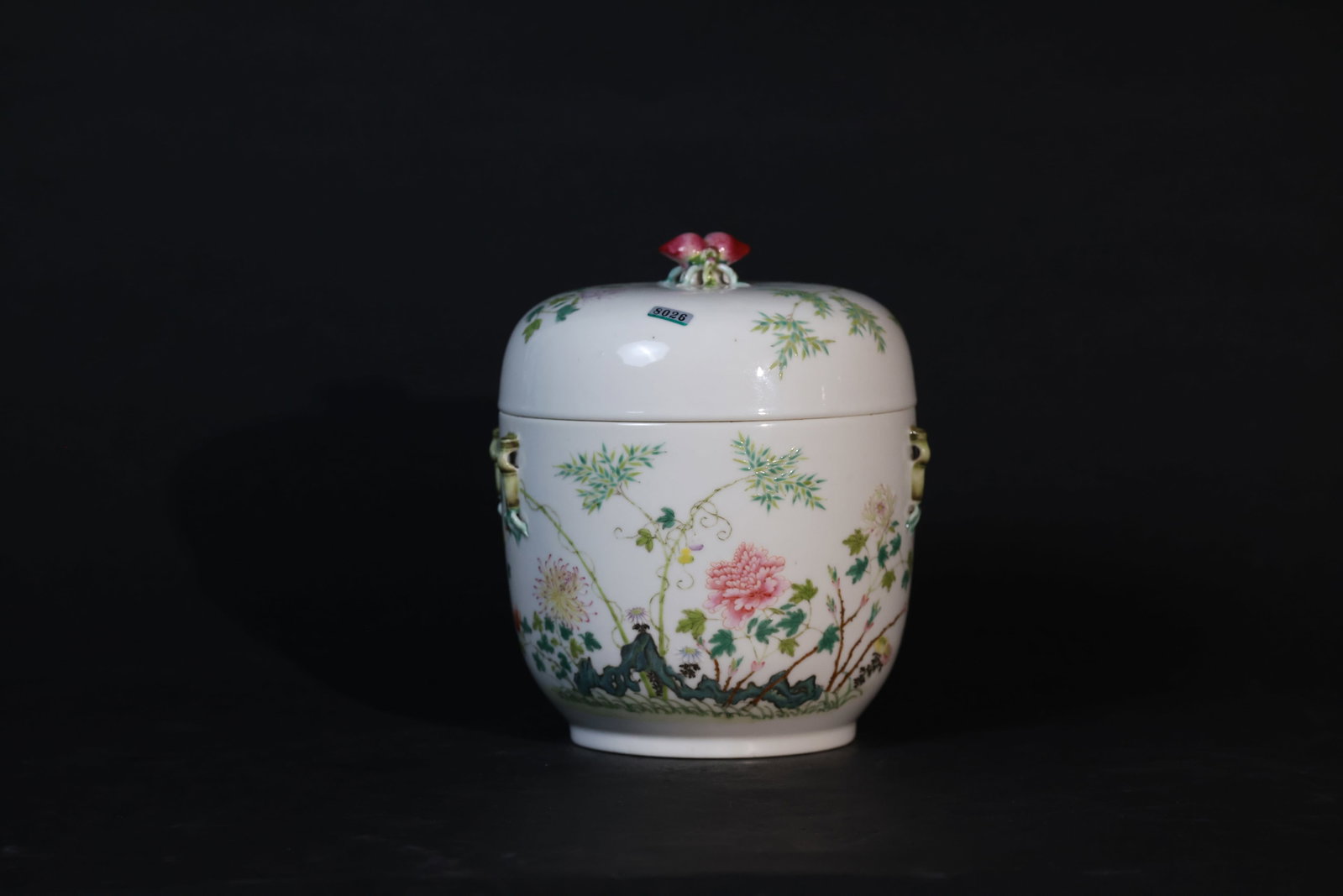 Qing Guangxu Famille Rose Floral Covered Jar with Peach Finial and Bamboo Handles: Overall intact and complete, with natural age-related patina to the glaze. Handles and knobs are undamaged; minor wear to the rim and foot consistent with use. No cracks or chips. H 21cm W 17cm