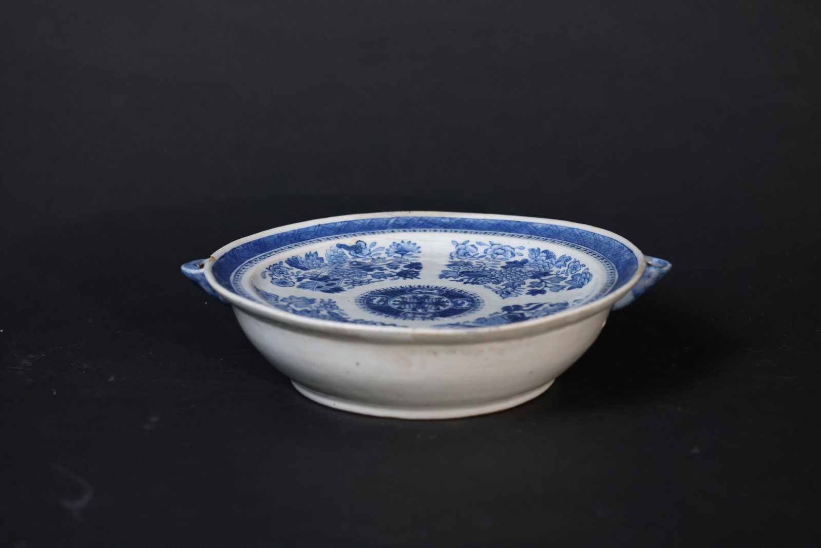 Qianlong Blue-and-White Incised Eight Immortals and Floral Warming Dish: Minor wear to the twin handles, slight glaze fritting to the rim, light surface wear to the interior, no cracks, overall in good condition. H 6.5cm W 14.5cm