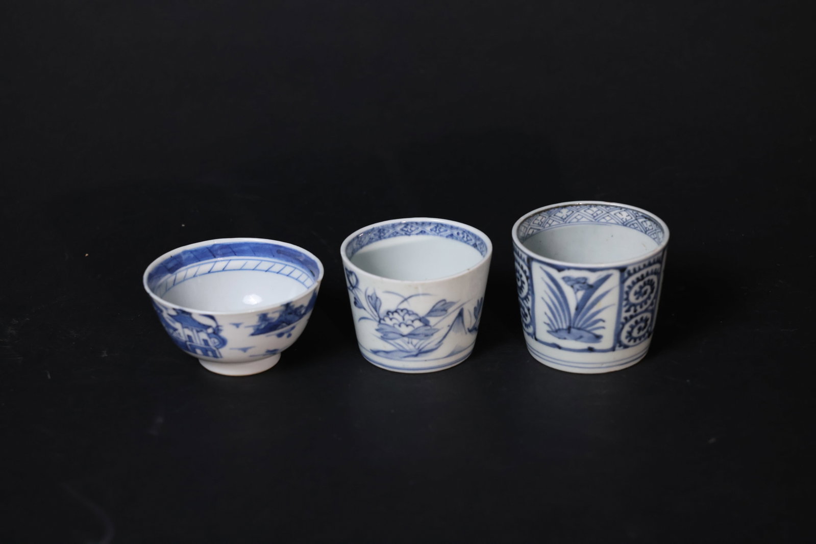 Chinese blue-and-white landscape cup; Chinese blue-and-white lotus-pond floral straight-sided cup;: Shanshui small cup with minor rim nick and fine firing line; Lotus pond straight cup with small glaze flake to rim, otherwise intact; Openwork orchid straight cup with slight rim glaze wear and typica