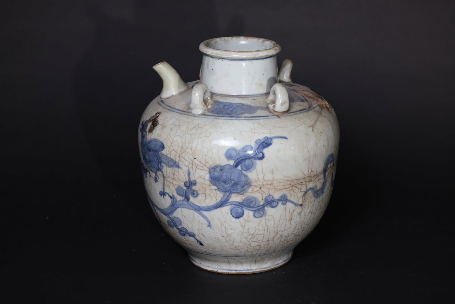 Blue-and-White Porcelain Teapot with Magpies on Plum Blossom (Si Xi form): Overall with extensive natural crackle; a long horizontal firing line visible on the body; some areas with old encrustations. Handle, knop, and spout all intact; minor wear to the rim. No recent chips
