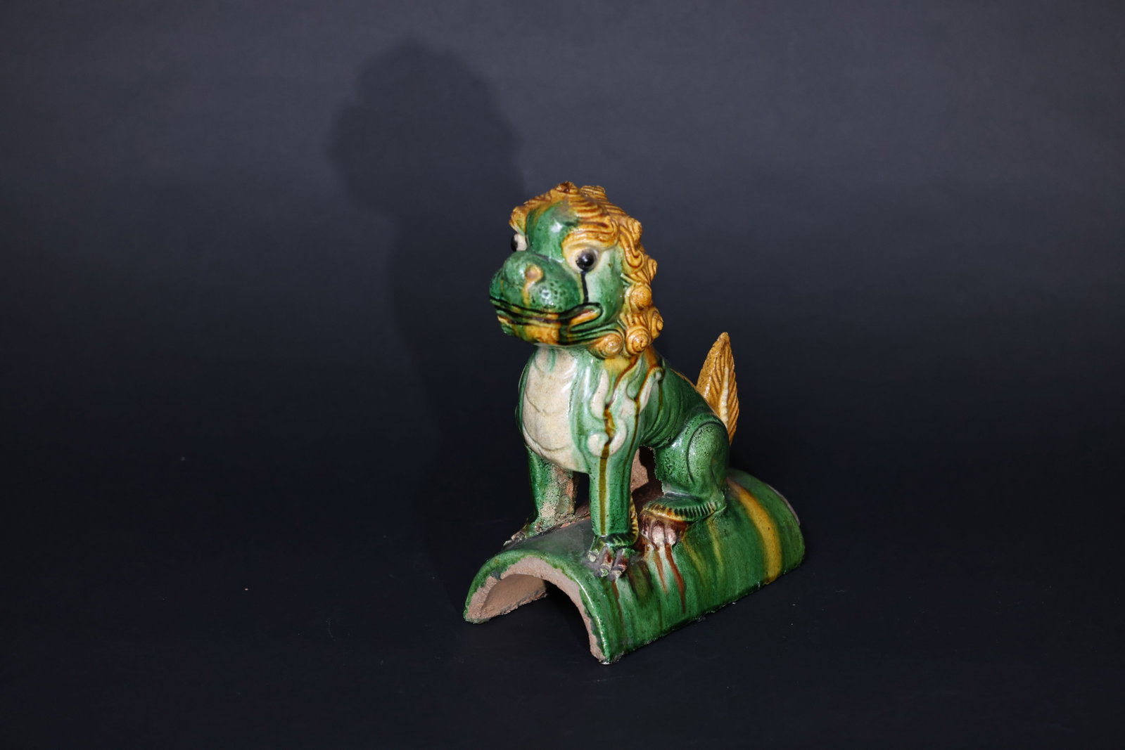Sancai-Glazed Lion Roof Ridge Beast: Overall intact. Minor nicks to the rim, with slight glaze flaking in areas. No breaks or repairs. Glaze well preserved. H 26cm W 22cm
