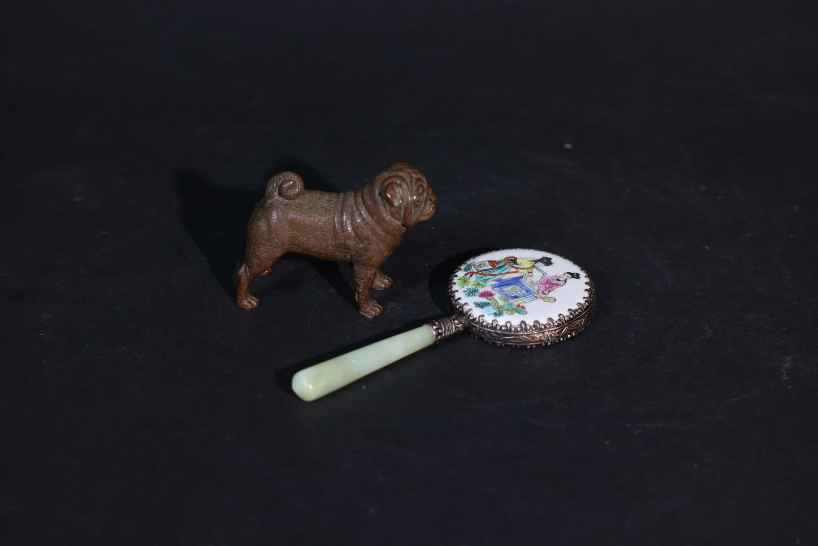 Late Qing/ROC Bronze Pug; Late Qing Export Porcelain Plaque Hand Mirror, Jade Handle: Bronze Pug Dog Figurine: In excellent condition with no damage or repairs. The patina is natural, with minor areas of green oxidation and no chips or cracks. Late Qing Export Mirror with Jade Handle: 