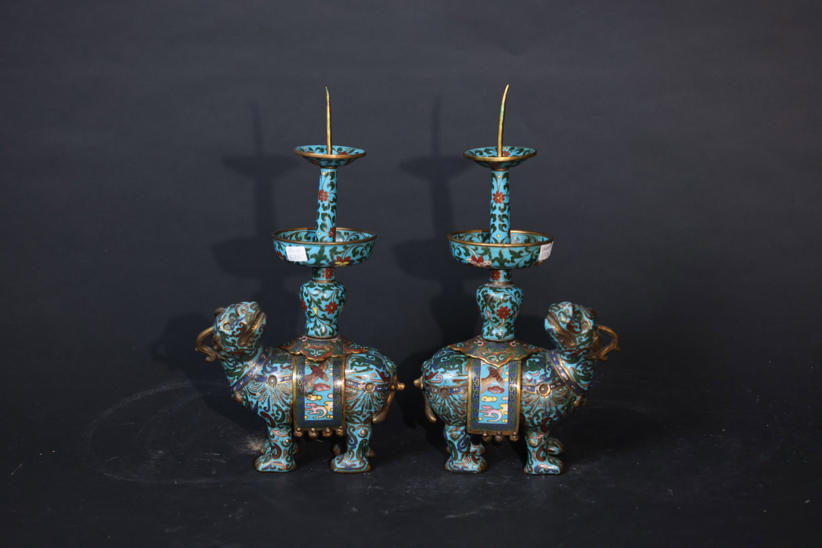 Pair of Late Qing Copper-Body Cloisonné Enamel Candlesticks with Auspicious Mythical Beasts: Minor enamel losses, some wear to the gilt, old patina, slight oxidation to the wax plug, no major damage or restoration, preserved as a matching pair and overall in good condition. H 32cm W 15cm