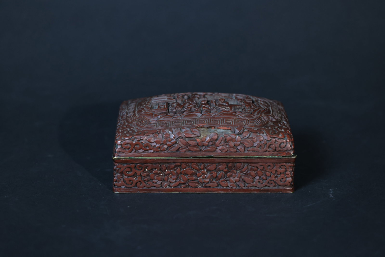 Carved Cinnabar (Tihong) Rectangular Lidded Box with Landscape and Figure Decoration: The lacquer surface shows multiple areas of old chipping and localized lacquer loss. The bronze rim has verdigris. The box body is intact with no cracks, and the lid opens and closes smoothly. H 6cm W