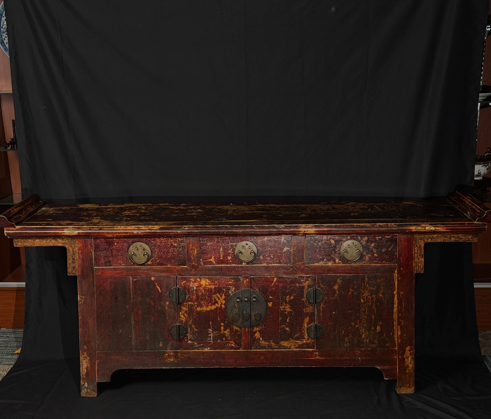 Late Qing vermilion-lacquer altar cabinet with upturned corners: Overall structure is complete and stable. Original lacquer shows age-appropriate wear, including natural craquelure, surface losses, and areas of flaking consistent with age. All original brass fittin