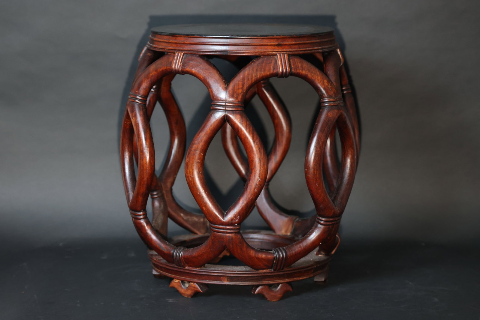 Chinese Rosewood Drum Stool with Rope-Pattern Carving: Overall structure is stable with minor splits at several mortise-and-tenon joints and some old repairs. Wood surfaces show typical age wear and small knocks; stone surface with scratches; brass namepl