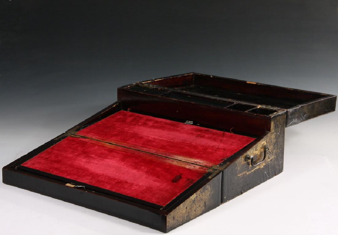 JAPANESE LACQUER WRITING BOX: Edo Period Black Lacquered Box with two-toned gold decoration of garden scenes with scholars and students, side lift handles, opens to reveal shallow wine velvet flat writing surface, which in turn op