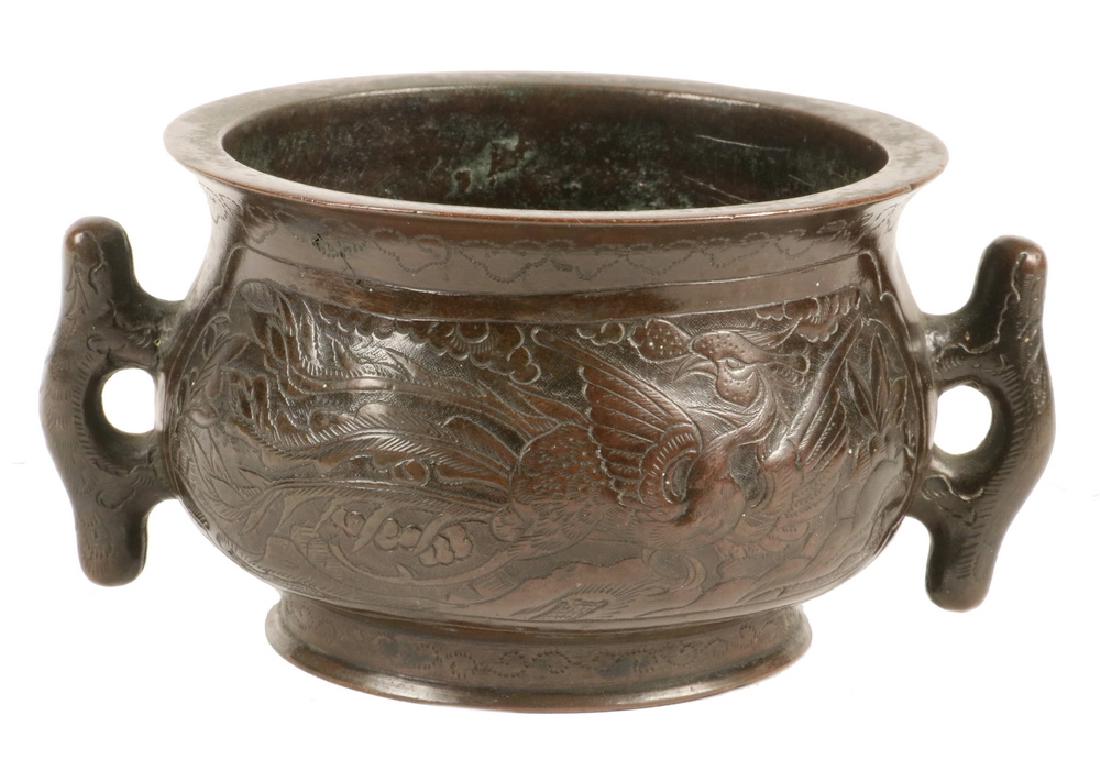CHINESE BRONZE LOW BOWL: Chinese Ming Style Bronze Handled Low Bowl with phoenix and dragon decoration, with engraved foot, impressed Xuande reign mark on base, 2 3/8" high, 4 7/8" wide. Good condition.