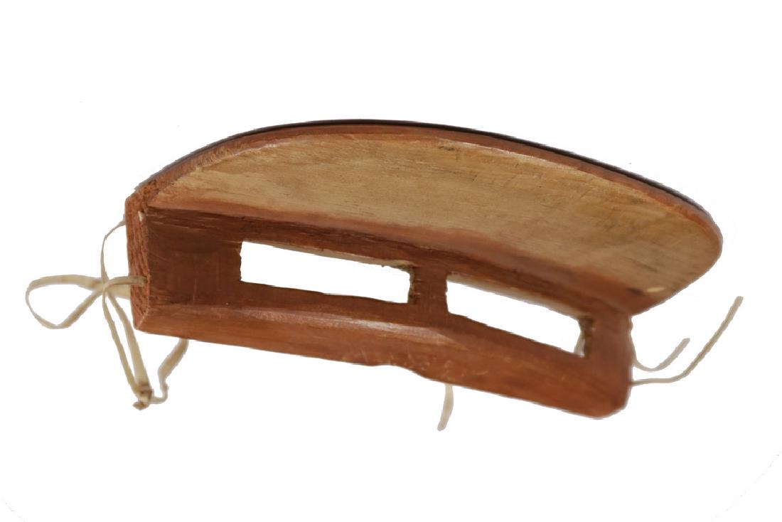 RARE INUIT SNOW GOGGLES: Early 20th c. Snow Goggles with integral visor, in carved wood with red stain, remnants of hide ties, 1 5/8" x 6 1/2" x 3 3/4". Very good condition.