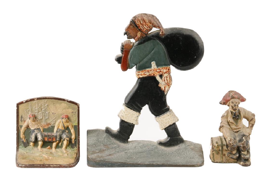 (3) PIRATE DOORSTOPS: Collection of (3) Early 20th c. Cast Iron Pirate Theme Doorstops, including: Pirate with a sack, flat back, original surface, 12" high, 9 3/4" wide, paint losses; Pirate sitting on domed top trunk, or