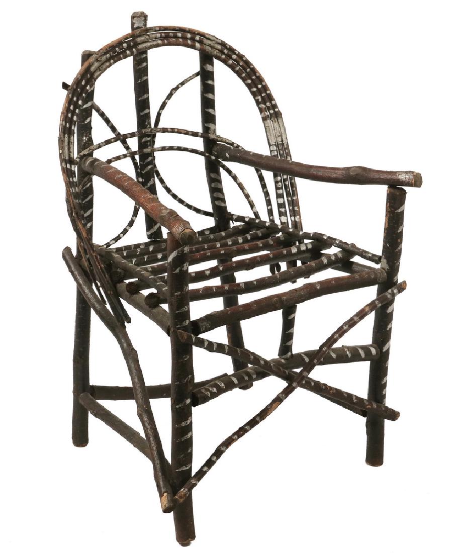 TWIG ADIRONDACK CHILD'S CHAIR: Late 19th c. Folk Art Bent Walnut Twig Armchair with arched back, decorated with touches of silver radiator paint, 12" seat, 17 1/2" arms, 25" back, 16 1/2" x 15". Good condition.