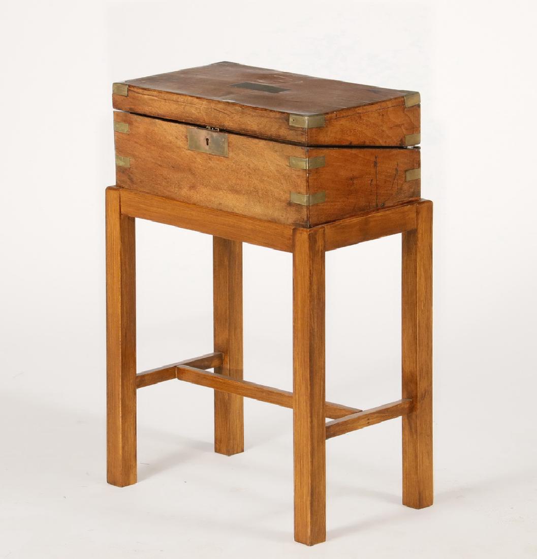 TRAVELER'S DESK ON STAND: British Brass Bound Mahogany Lap Desk with replaced red leather writing surface, but retaining pen tray and hidden drawers. On a later stand. 24" x 16 1/2" x 10". Stand is rickety.