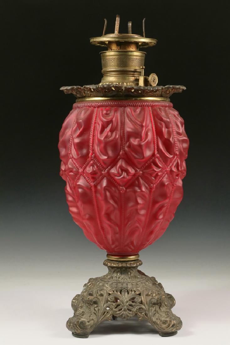 SATIN GLASS KEROSENE LAMP: Gone with the Wind Parlor Lamp having a Fostoria Red Satin (Cerise) Ruched Drapery Pattern Glass Base, gilt spelter fittings, retaining the original font, but now electrified. 19" tall, 7 1/2" diam. G