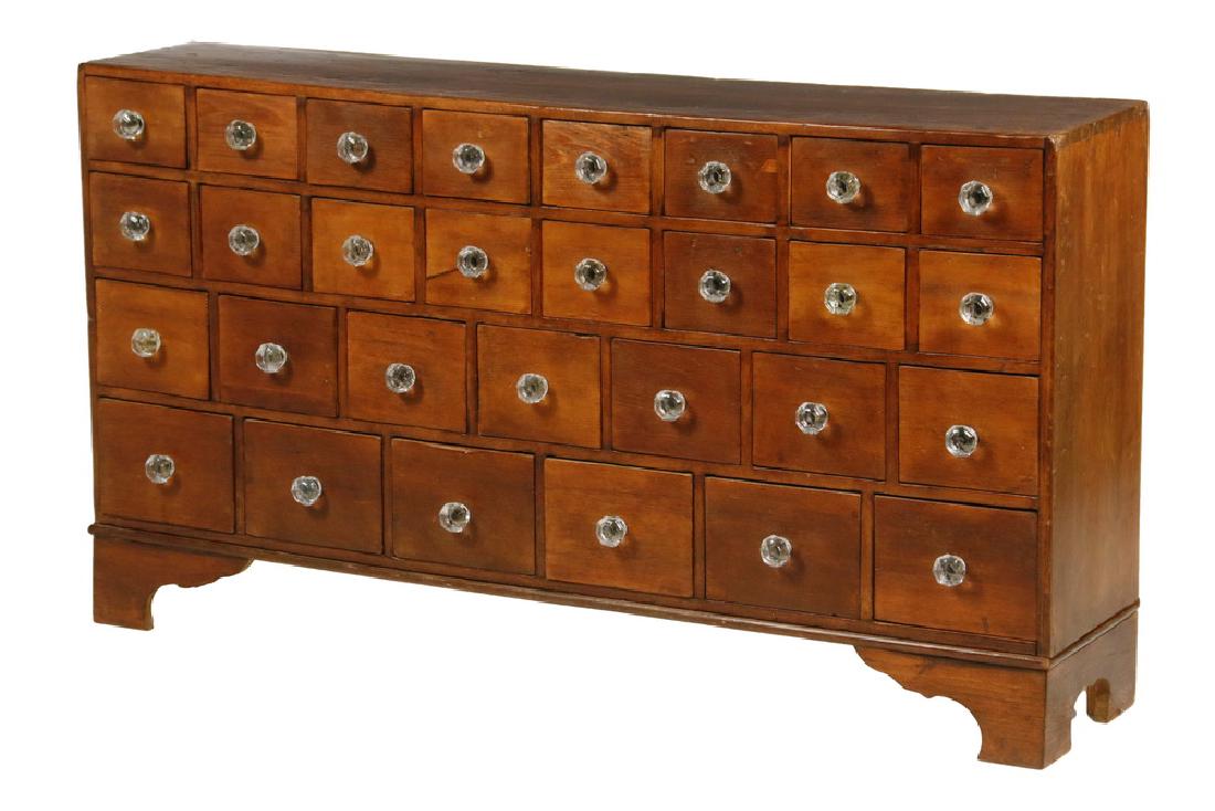 COUNTRY APOTHECARY CABINET: 19th c. New England Pine 29-Drawer Medicinal Cabinet, having two ranks of eight over a rank of seven and a rank of eight drawers, all with glass knobs. Set on a later bracket base. 25" x 46 1/2" x 11"