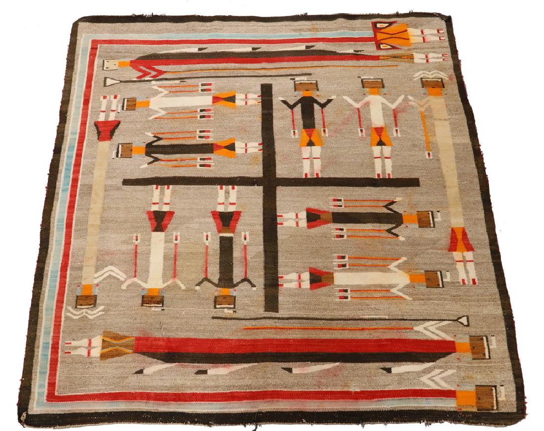 NATIVE AMERICAN RUG - 67" x 68": Circa 1900 Vintage Navajo Yei-Bi-Chei Rug with sand field, black brown border and figures in tan, orange, crimson, turquoise and buff, having a central wheel with four pair of young men in alternating
