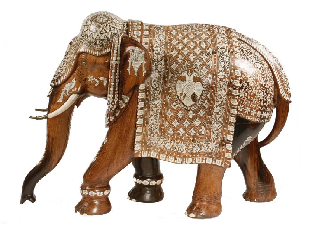 ANGLO-INDIAN ELEPHANT CARVING: Late 19th to early 20th c. Beautiful and Monumental Striding Elephant, made for the Russian or Austro-Hungarian Empire, with double-headed eagle shields on the side tabards, brass capped tusks, roughl