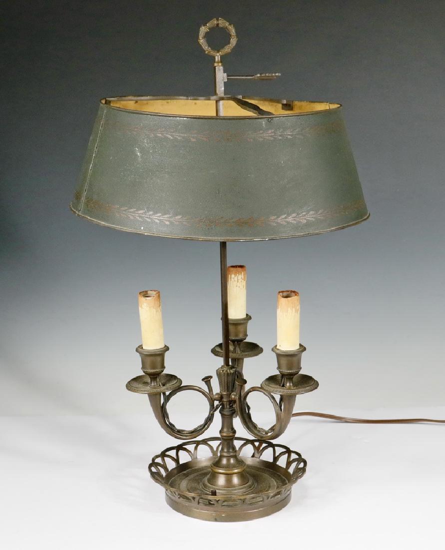 FRENCH BOUILLOTTE LAMP WITH TOLE SHADE: Ca. 1930s French Empire Style Bouillotte Brass Table Lamp with Tole Painted Shade, reticulated round base, with three candle socket fixtures with French horn shape stems, arrow and wreath form finial,