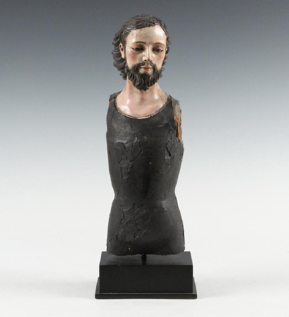 ECCLESIASTICAL SCULPTURE: 18th c. Spanish Colonial Bust of San Jose, in polychrome hardwood with glass eyes, black painted torso, mounted on a museum stand, 15 1/4" x 5 1/2" x 4" overall. Minor loss to pigment on head.