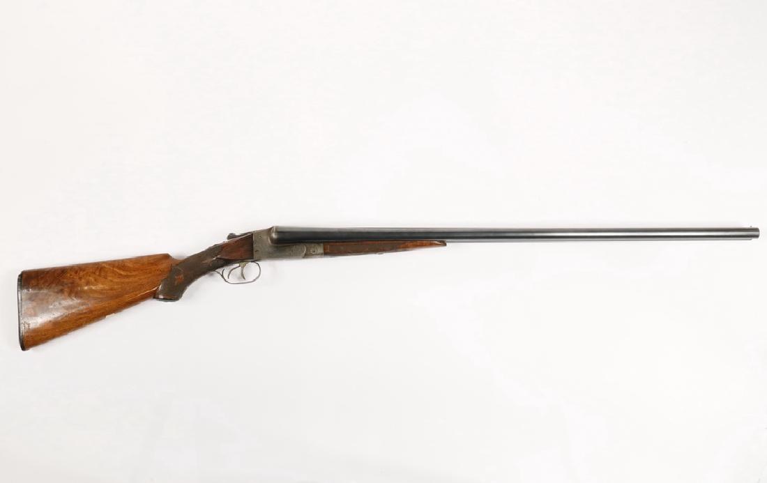 ITHACA 12 GA. DOUBLE BARREL SHOTGUN: Nicely engraved with game and hunting dog, engraved stock, gold shield for monogram (not engraved), s/n 117328. First year model was made. 32" barrel, 49" overall. Good condition.