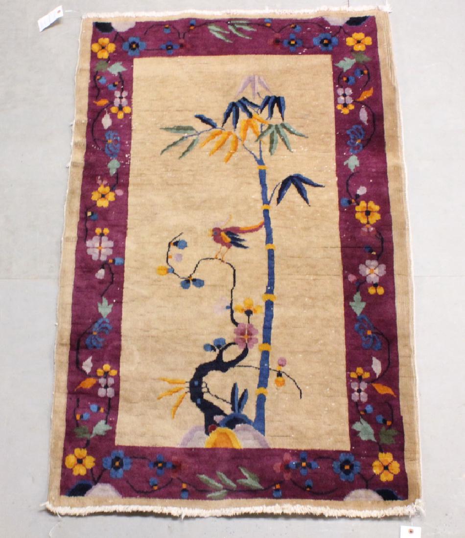 CHINESE RUG - 3'-1" x 4'-9": Second quarter 20th c., a palm tree and floral motifs with a single parrot in midnight blue, gold, Persian blue, rust and plum on the tan field, plum vine and rosette border. Areas of wear, stains.