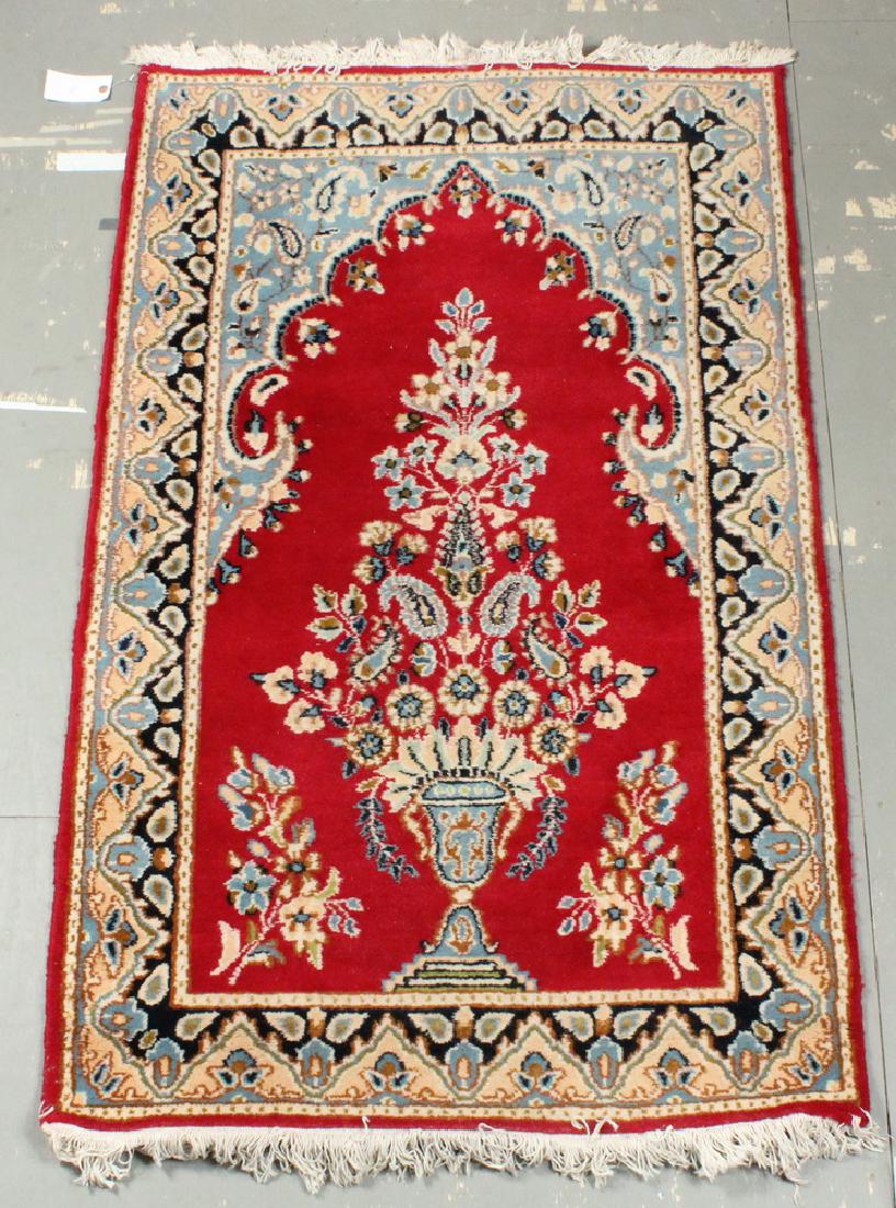 KERMAN PRAYER RUG - 3' x 5': Iran, mid-20th c., large vase with flowering vines and boteh in sky blue, ivory, midnight blue and rust on the red field, sky blue spandrels, midnight blue and tan-gold border. Good condition.