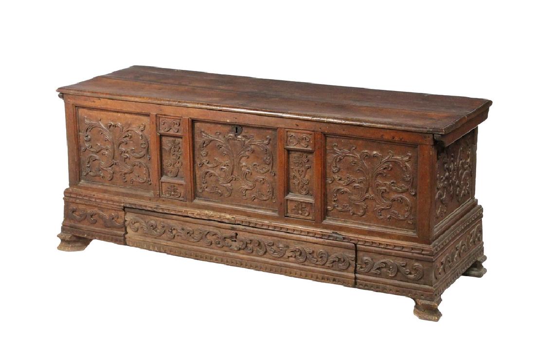 17TH C. CONTINENTAL WALNUT CASSONE: Large Low Six-Plank Chest, probably Italian, with heavy molded hinged top, having delicate overall floral carving in three panels on the face, small intermediate panels, concealed drawer in lower frie