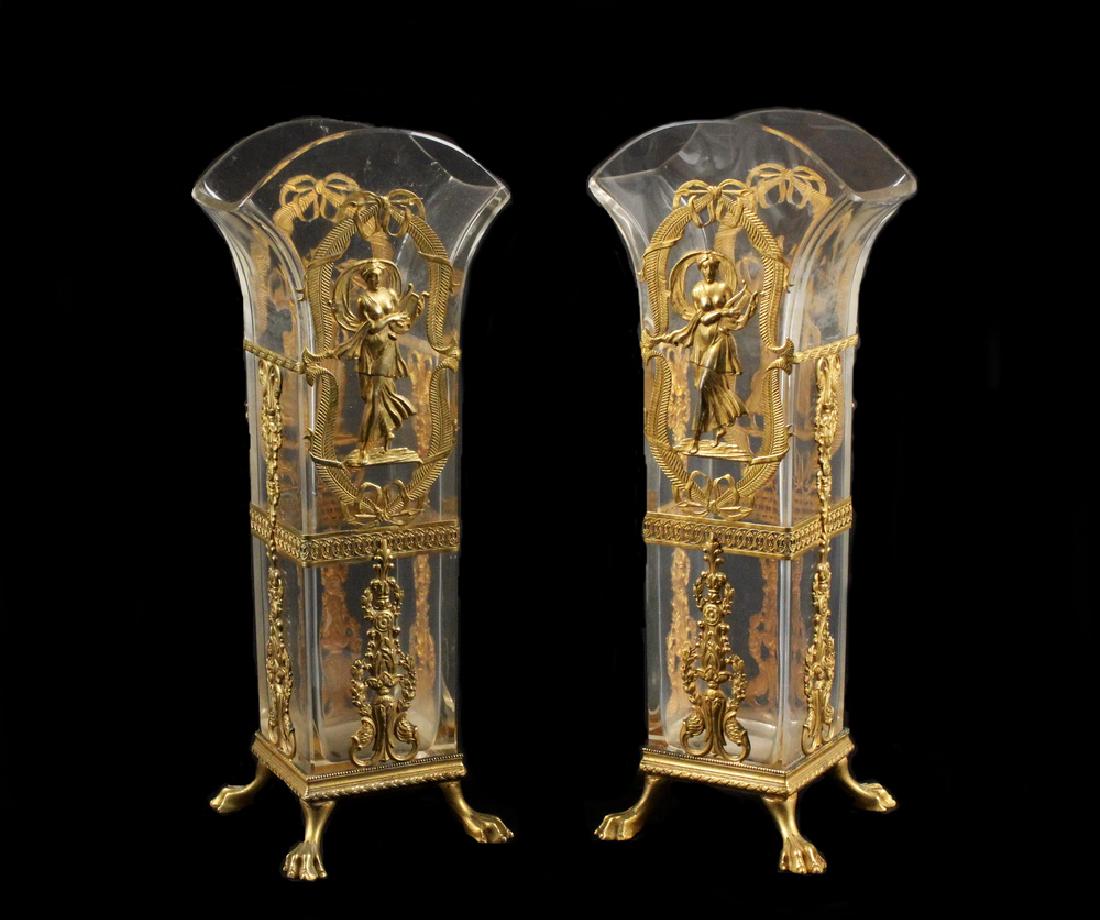 PAIR ORMOLU MOUNTED CRYSTAL VASES: Pair of 19th c. French Empire Gilt Bronze Mounted Clear Crystal Vases, square shaped base and flared crystal rims, bronze mounts depict finely detailed Classical female figures amid foliate swags and 