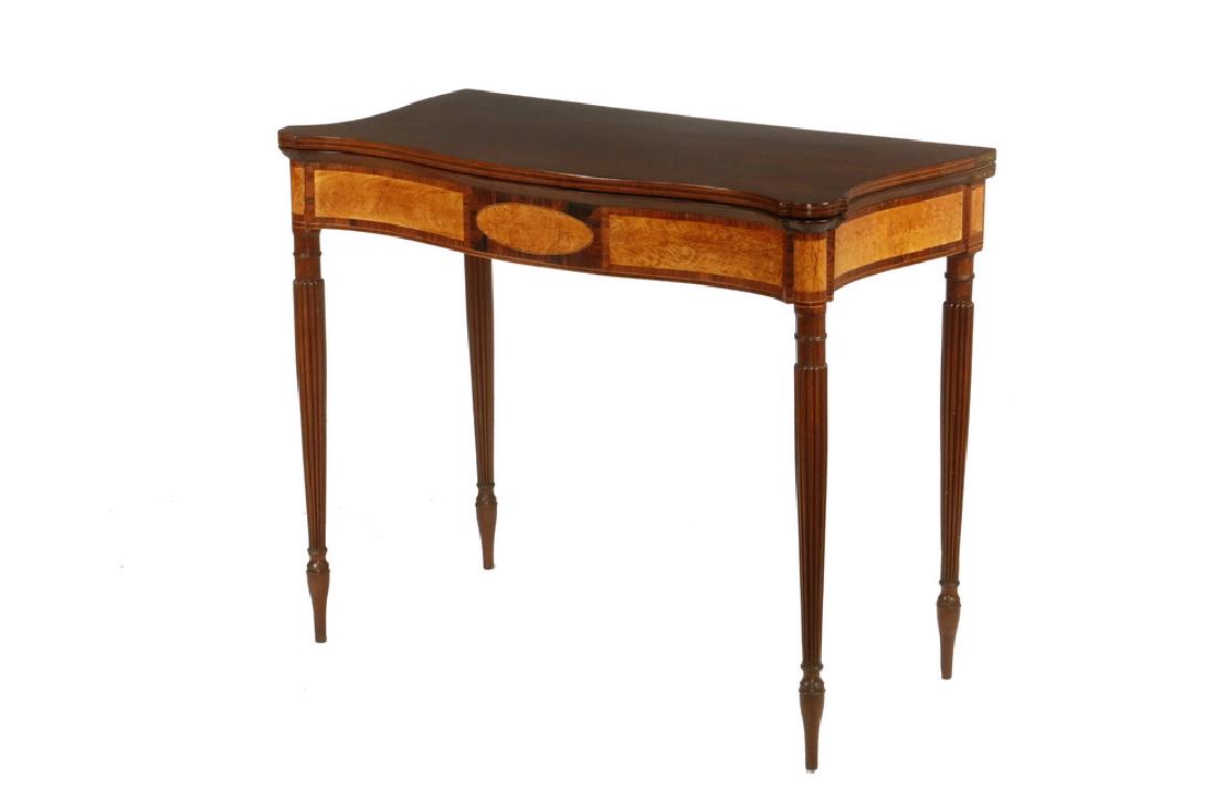 AMERICAN COLONIAL SALEM CARD TABLE: Sheraton Mahogany and Satin Flame Birch Card Table, circa 1790-1815, having a serpentine shaped molded edge top with hinged leaf, conforming shaped and paneled inlaid frieze, raised on delicate turned