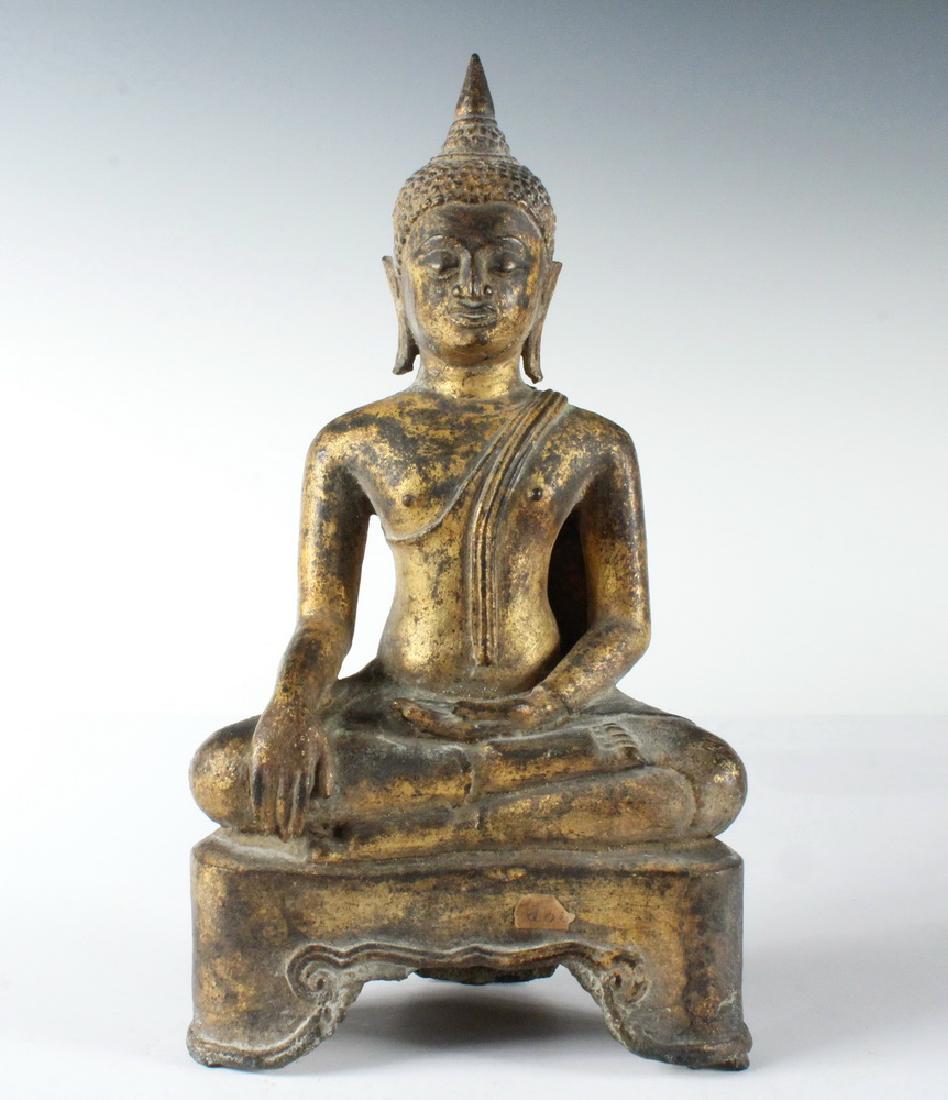17TH - 18TH C. THAI GILT BRONZE ALTAR FIGURE: Sukhothai Dynasty Seated Buddha, in serene pose, on an integral platform with remnants of the sand casting fill on the underside, 9" tall. Lovely patina.
