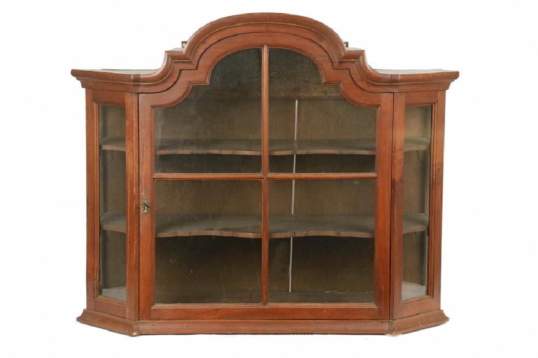 SMALL CONTINENTAL WALL CABINET: Early 18th c. Arch Top Wall Display Cabinet, Queen Anne period, probably Dutch, in mahogany, with a molded top, single four-light conforming door with molded mullions (lock with key), canted glass cor